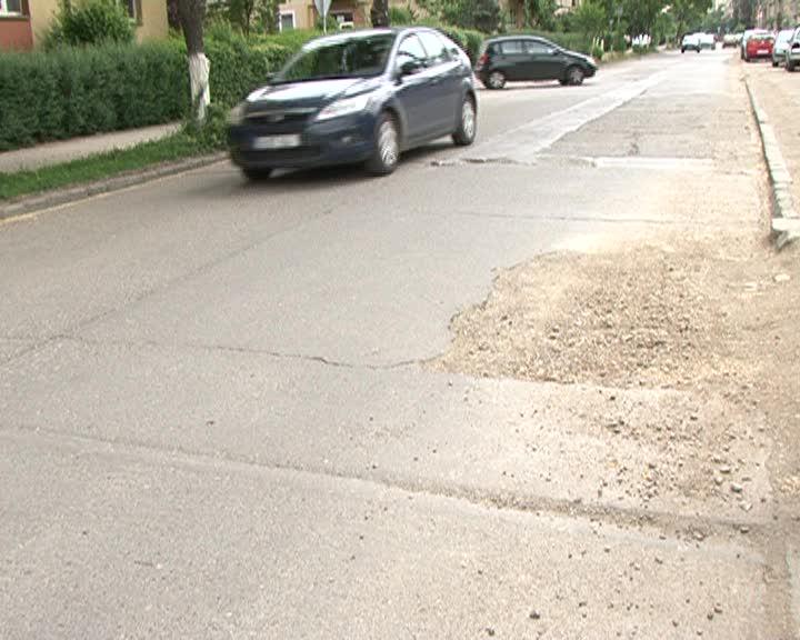 O stradă plină de gropi a adus mânia şoferilor asupra lui Boc. Când va fi asfaltată? 