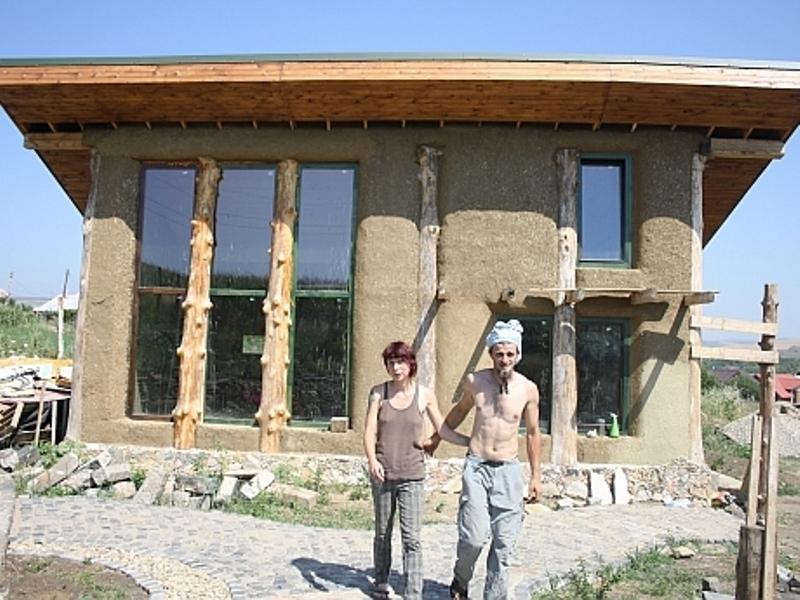 Sătui de bănci, doi tineri din Turda şi-au făcut propria casă, din paie, independentă energetic