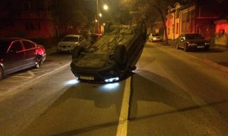 Maşină cu roţile în sus, pe mijlocul unui drum din Cluj. Şoferul a fugit: "E de două ore aici, poliţia se învârte pe lângă ea"