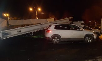 Dezastru într-o parcare din Cluj! 5 mașini, strivite de un panou publicitar smuls de vânt