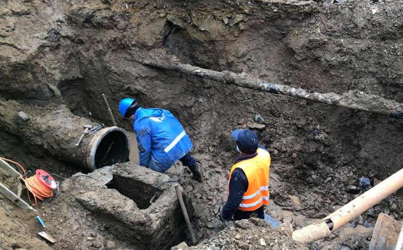 Circulația afectată pe strada Dragalina după inundația de ieri. Muncitorii lucrează pentru remedierea problemei