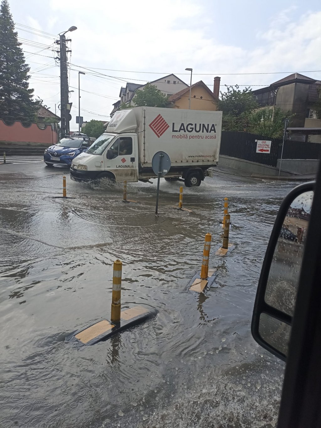 Ploaia a făcut, din nou, ravagii la Cluj! Sens giratoriu, înecat sub ape. Noroc cu stâlpișorii...