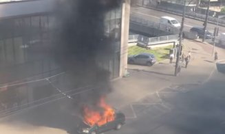 Flăcări și fum în Piața Mihai Viteazu. O mașină arde în plină stradă