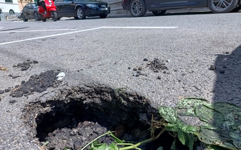 Cluj-Napoca: La un an distanţă, "Gaura neagră" misterioasă de pe trotuarul străzii Crişan s-a mutat pe carosabil