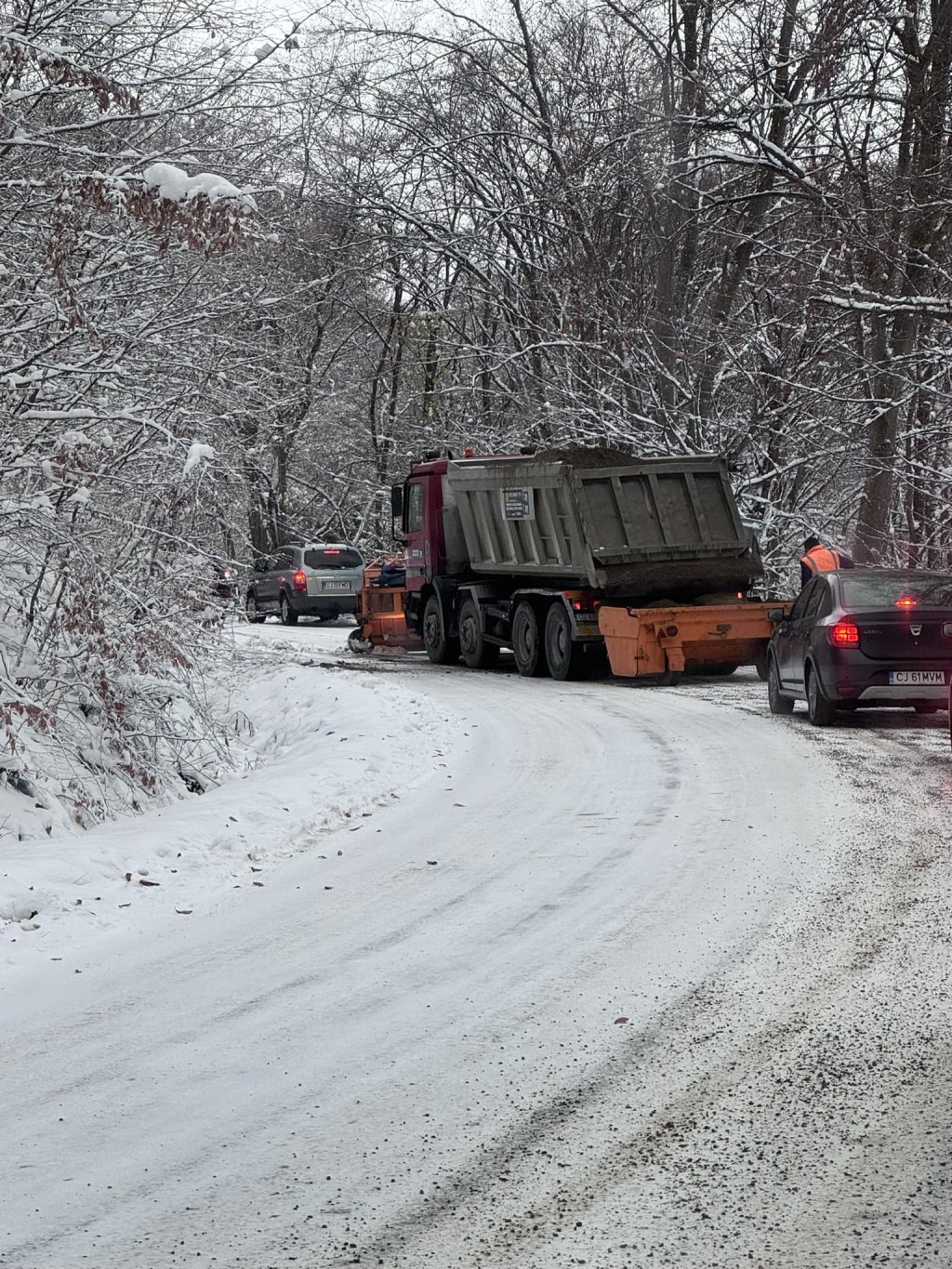 Drum periculos în Făget: Un utilaj de deszăpezire se chinuie să treacă de maşinile oprite pe marginea şoselei / "Sălicea! Oglindă pe jos"