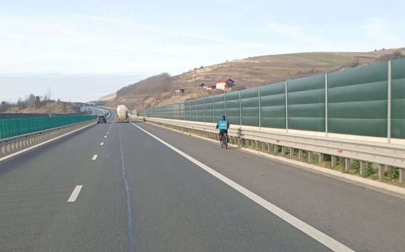 Imaginea ZILEI: Un livrator pe bicicletă, surprins pe banda de urgență a autostrăzii A3, în Cluj. „Să nu se răcească mâncarea"